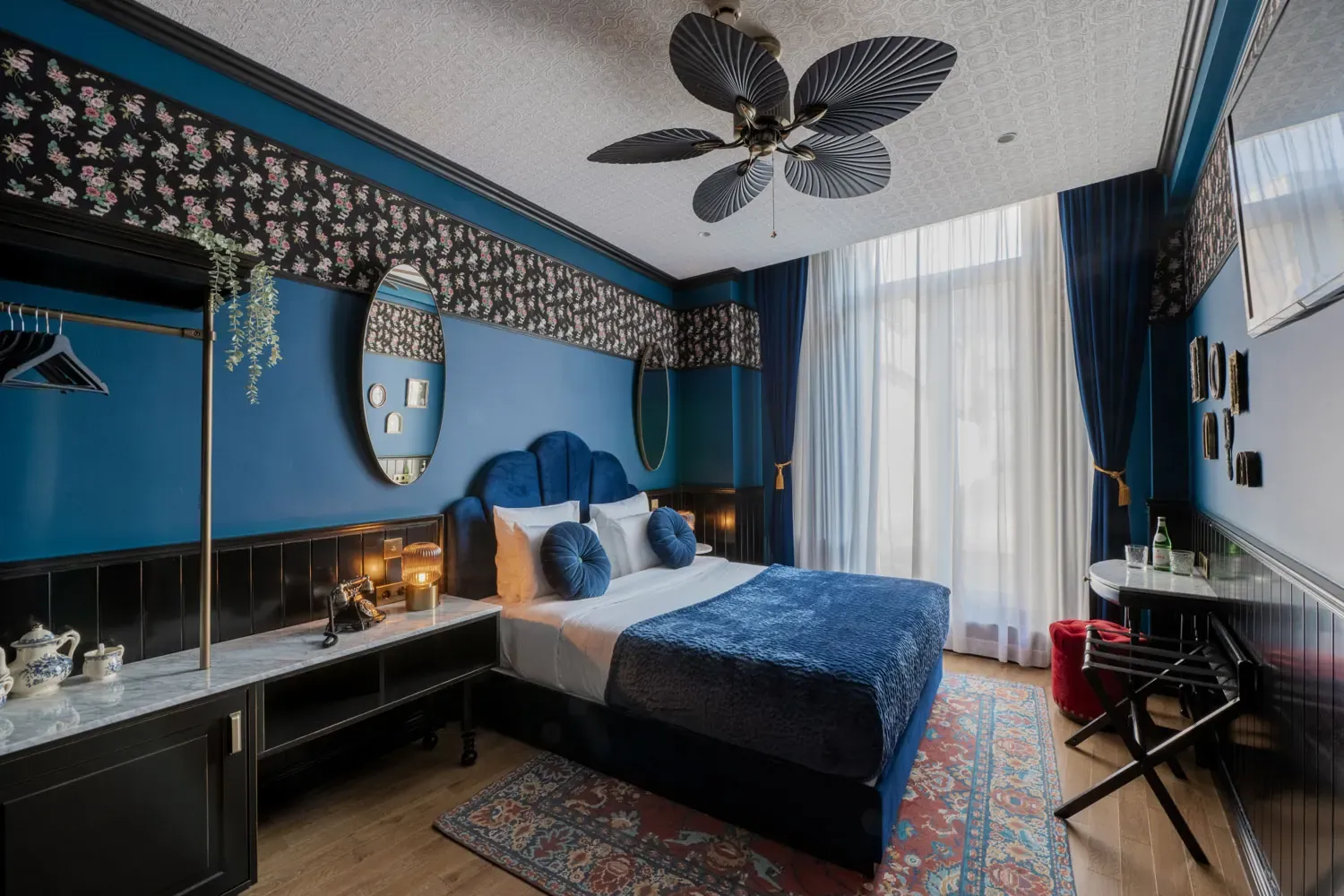 Double room at Craves Hotel: large bed, blue velvet headboard and floral wallpaper