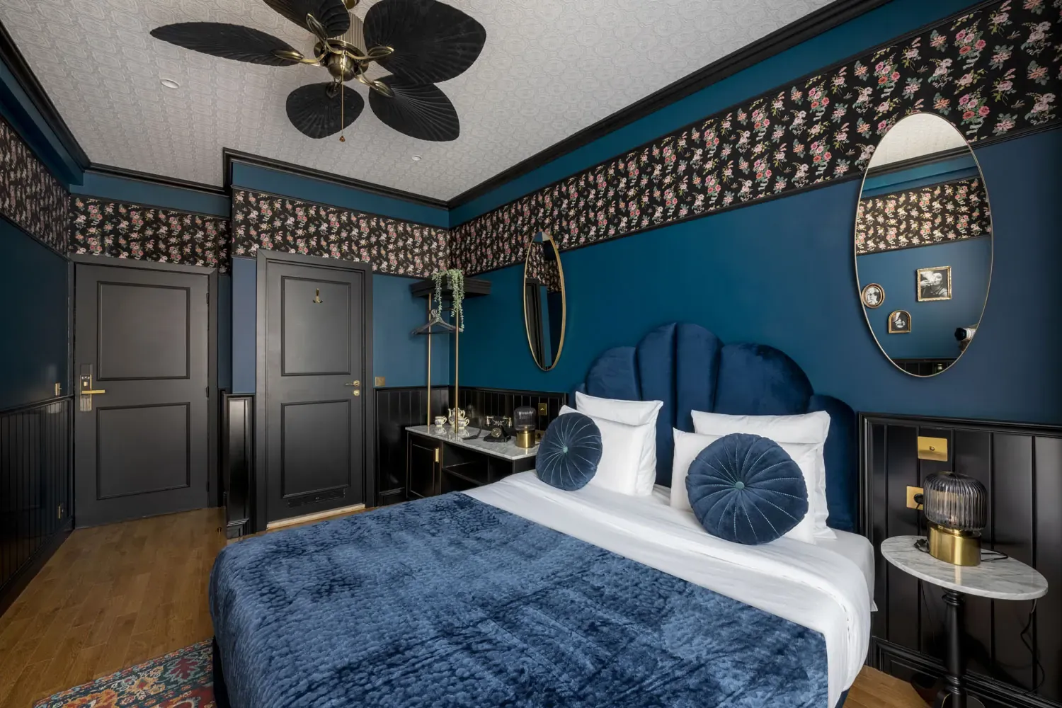 Double room at Craves Hotel: bed, blue velvet headboard and floral wallpaper