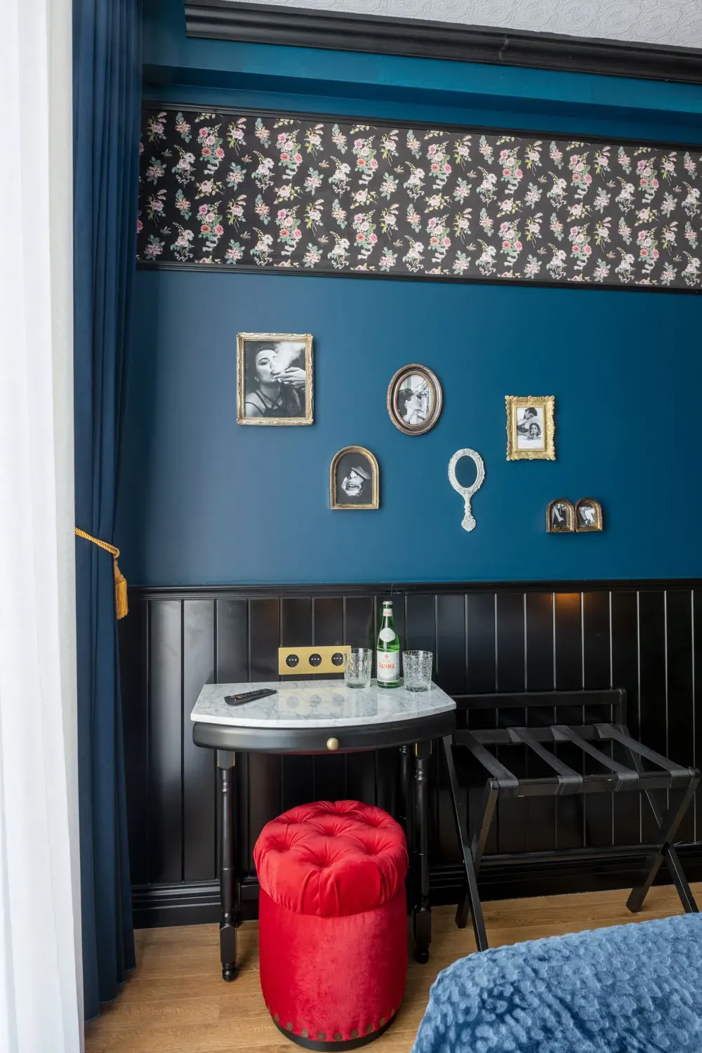 Dressing table, vintage frames and red pouffe in the double room