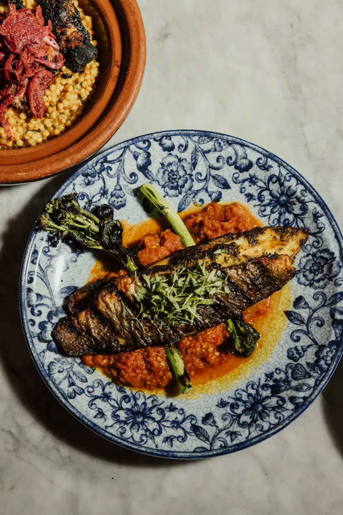 Grilled fish served on a blue earthenware plate