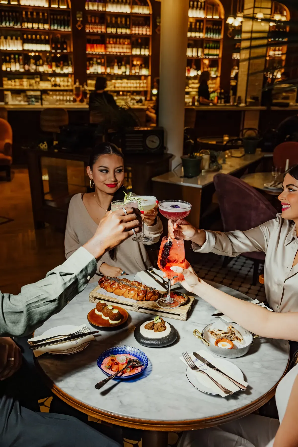 Guests raising a toast over mezze at Le Conteur restaurant