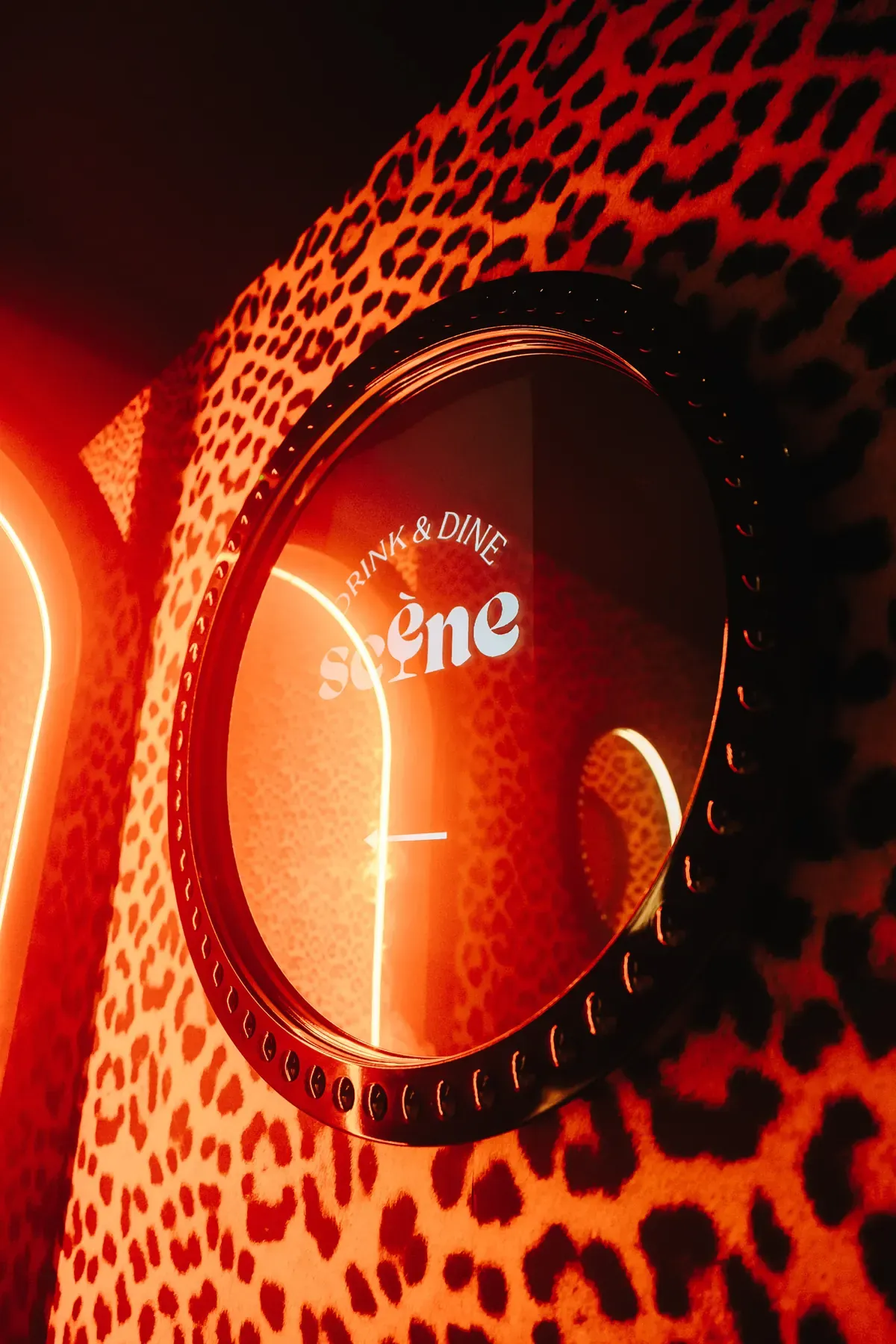 Scène sign on a leopard-print background, red light